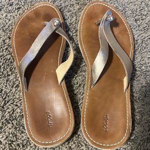 Olukai dress sandals with gold glitter straps.